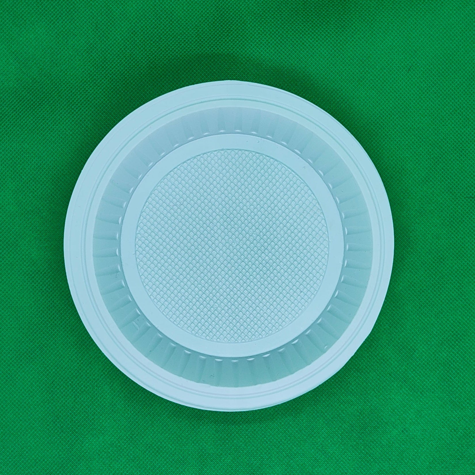 A white circular plastic lid or cover with a textured center